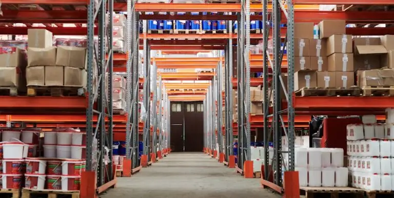 Wide angle view of a warehouse with stocked shelves and boxes.